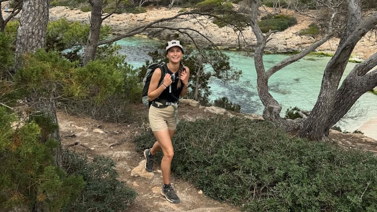 Die abwechslungsreiche Landschaft des Camí de Cavalls und die funktionale Trekking-Bekleidung von Salewa sorgen unterwegs für gute Laune. Immer auf Heidis Kopf: Die Hemp Flex 5 Panel Cap als luftiger Schutz gegen die Sonne.