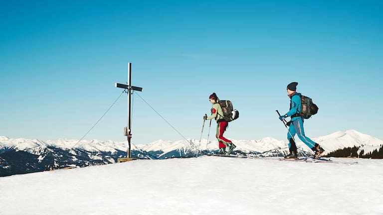 Ein Panorama wie aus dem Bilderbuch präsentiert sich Skitourengehern am Gipfel des Rosenkogel. Als Höhepunkt und idealer Fotospot wartet das Gipfelkreuz.