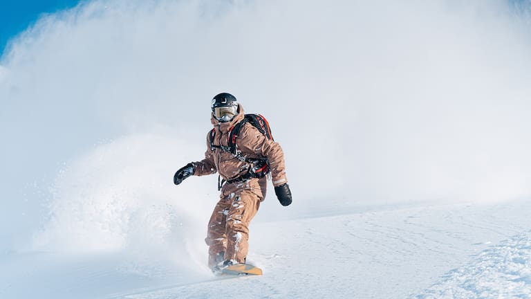 Camille Armand auf seinem Snowboard beim Carven durch den Pulverschnee.