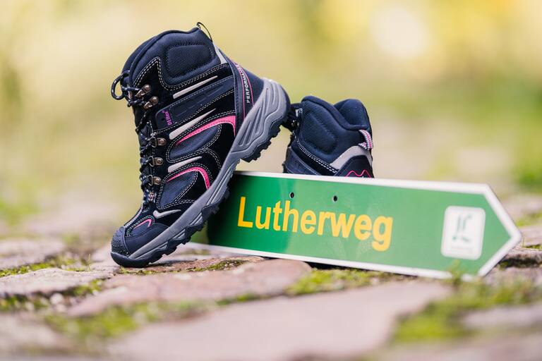 Lutherweg Sachsen Schild und Wanderschuhe