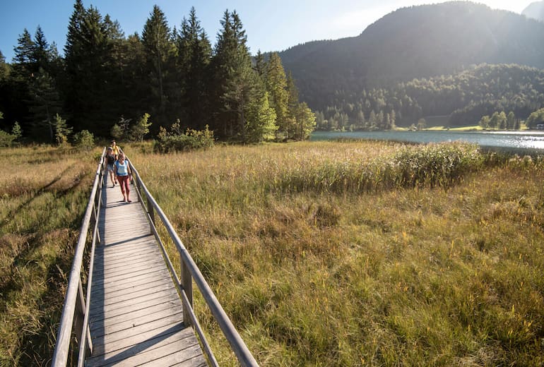 Wanderer am Lautersee mit Alm im Hintergrund